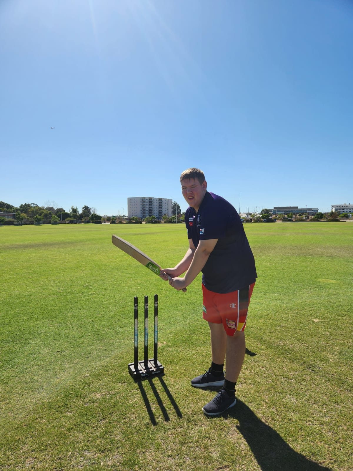 A teenager batting during a game of cricket