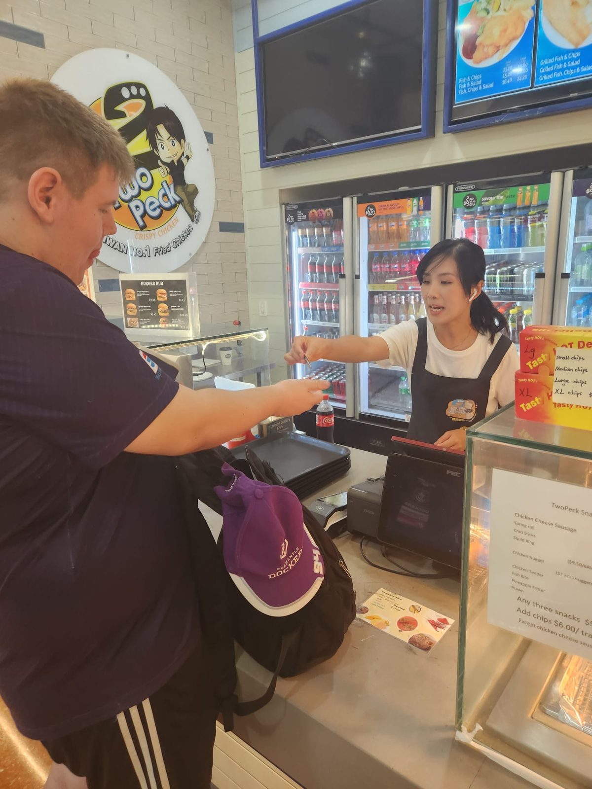 A teenager ordering his own lunch at a food counter