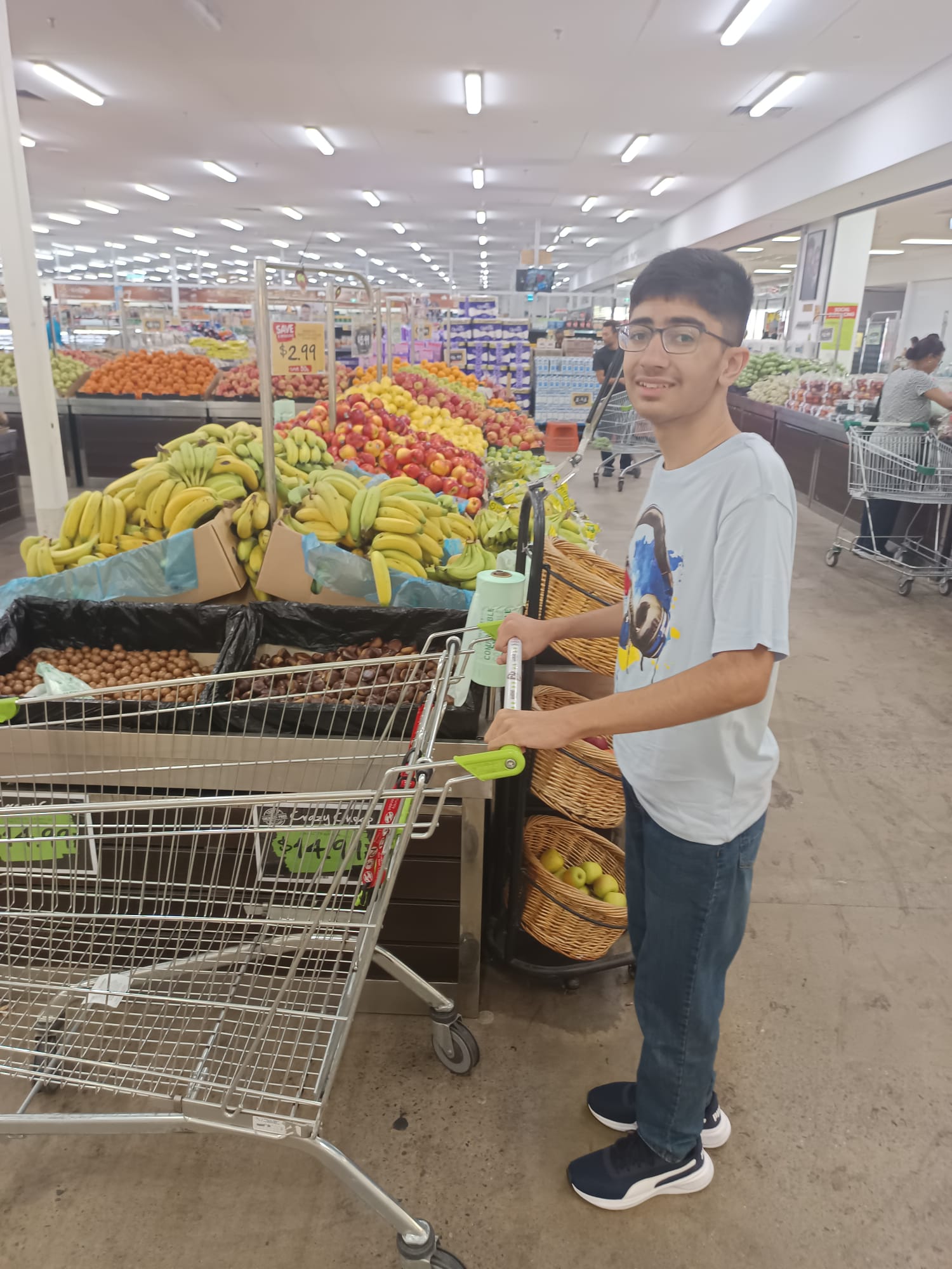 A teenager pushing a trolley through the supermarket
